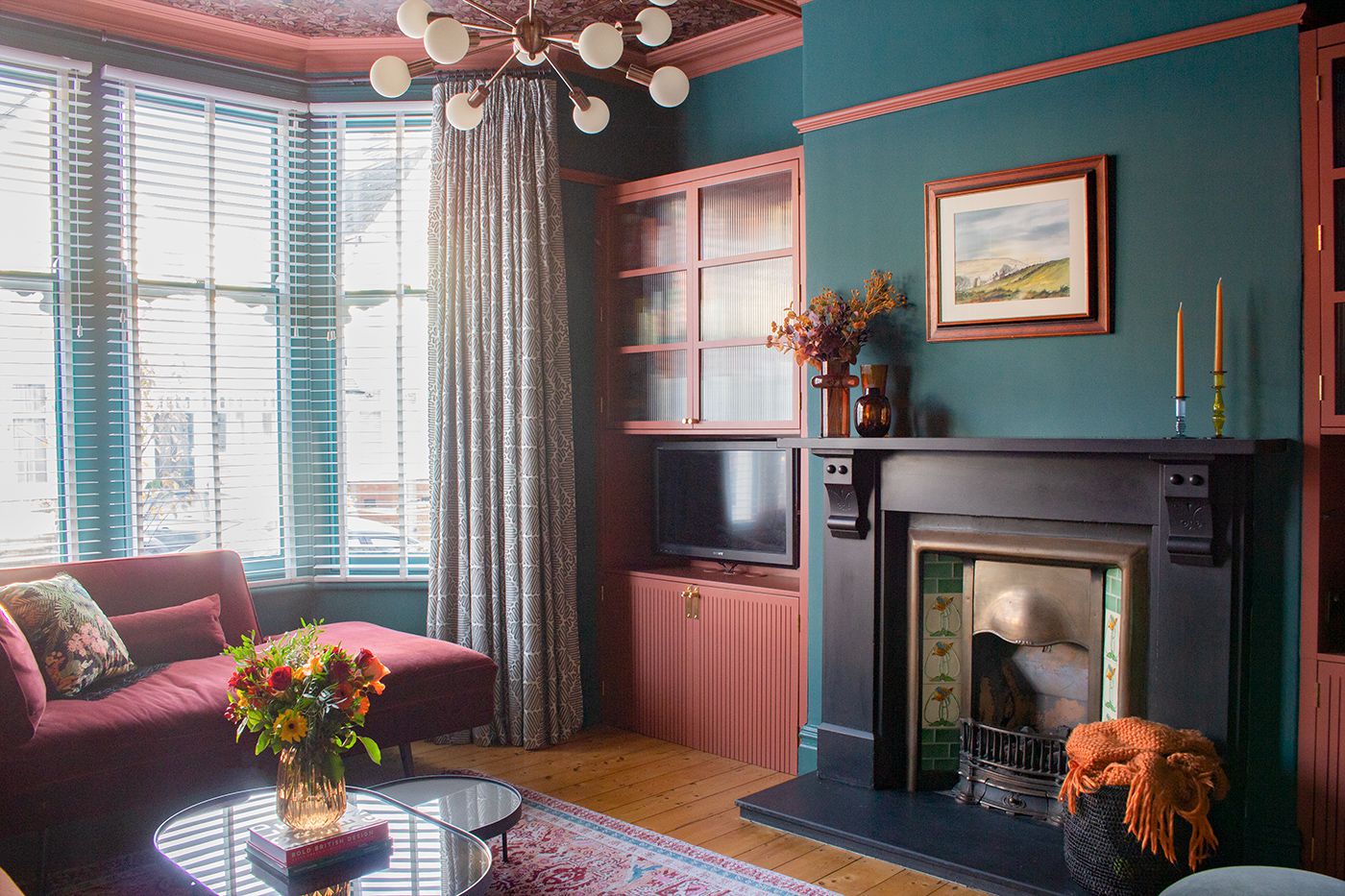 A wide shot of the room showing the red painted cabinets with fluted glass doors.