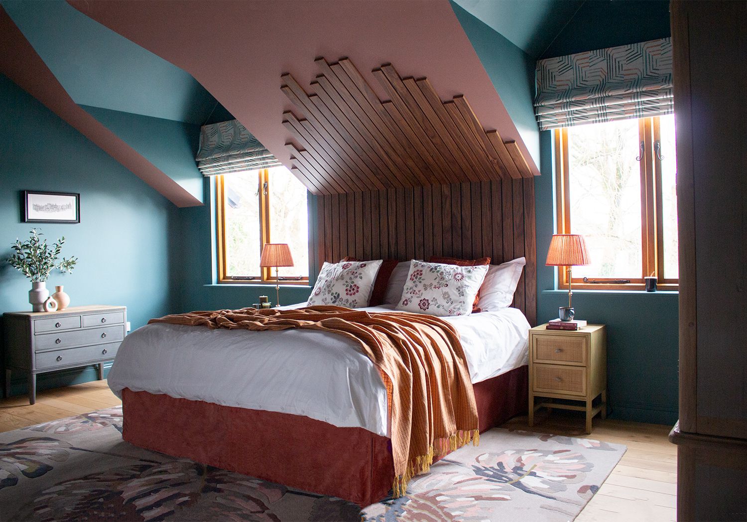 A photo of the main bedroom showing the velvet edged bed and the bespoke walnut headboard.