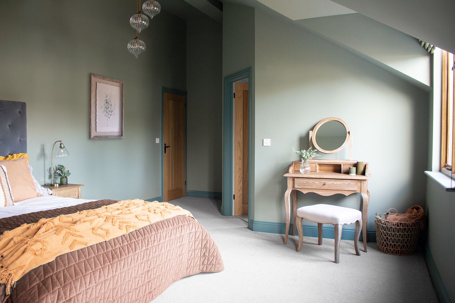 A photo of the upstairs guest bedroom showing the dressing table and stool, along with the bed.