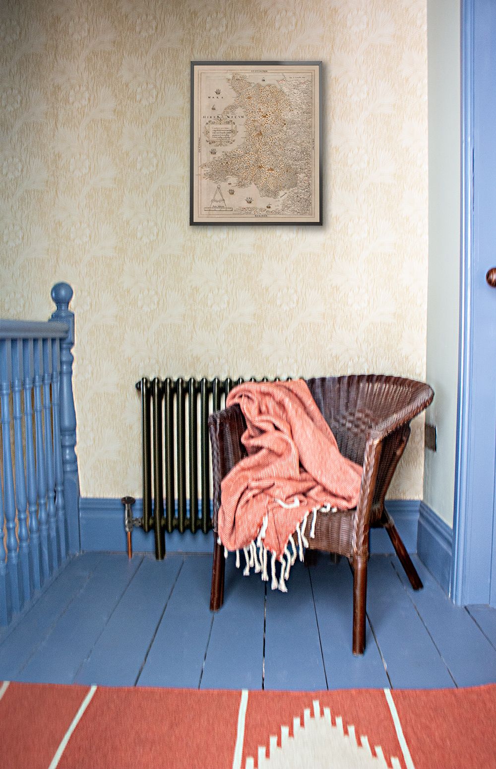 A photo of the space on the landing which has been turned into a reading nook with a chair and a rug.