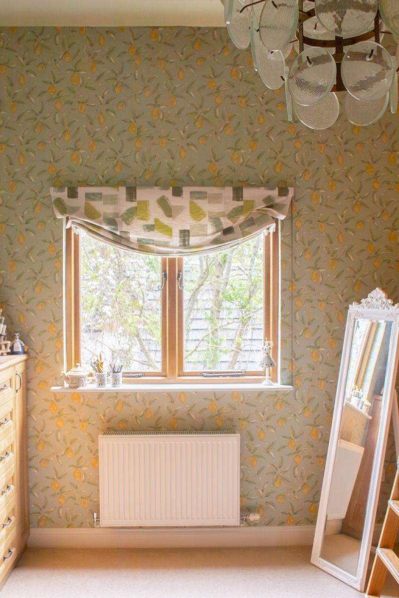 A photo of the sewing room showing the lemon and floral wallpaper with coordinating London blind.