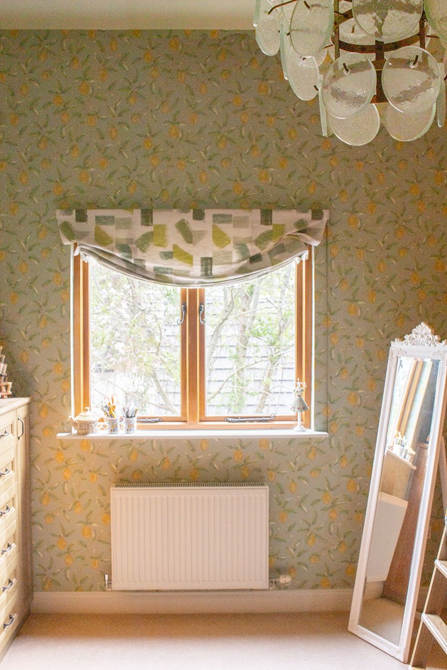 A photo of the sewing room showing the lemon and floral wallpaper with coordinating London blind.