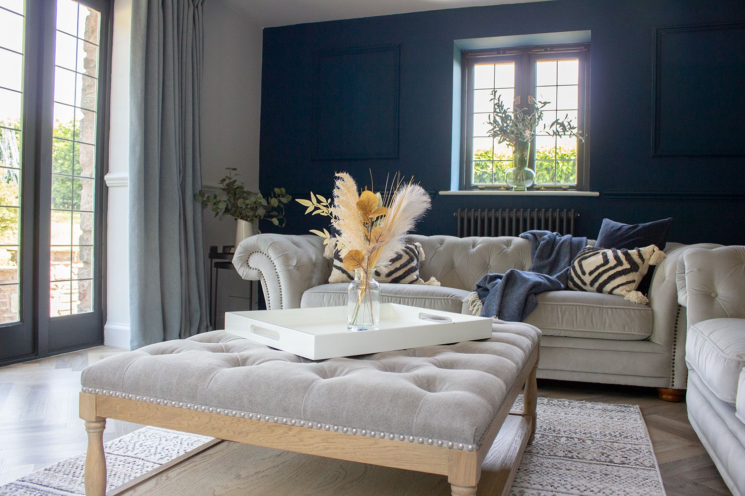 A photo showing the buttoned coffee table and sofas in the living room, with a rug under the coffee table.