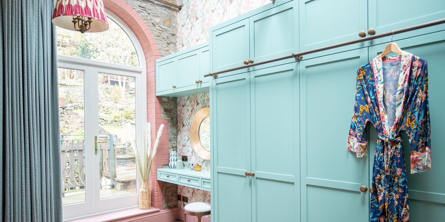A photo of bespoke pale teal painted wardrobes with a built in dressing table.