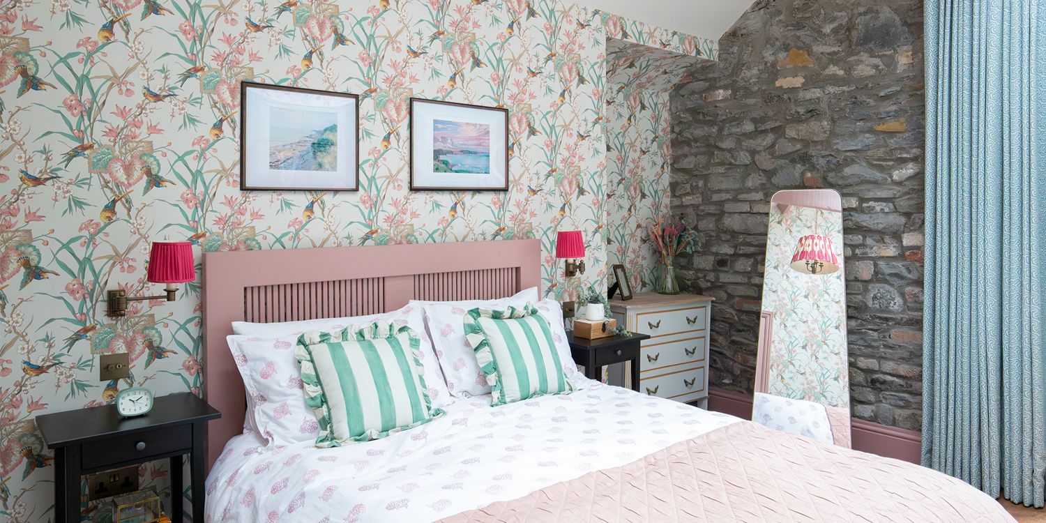A photo showing the pink double bed with the birds and flowers wallpaper behind.