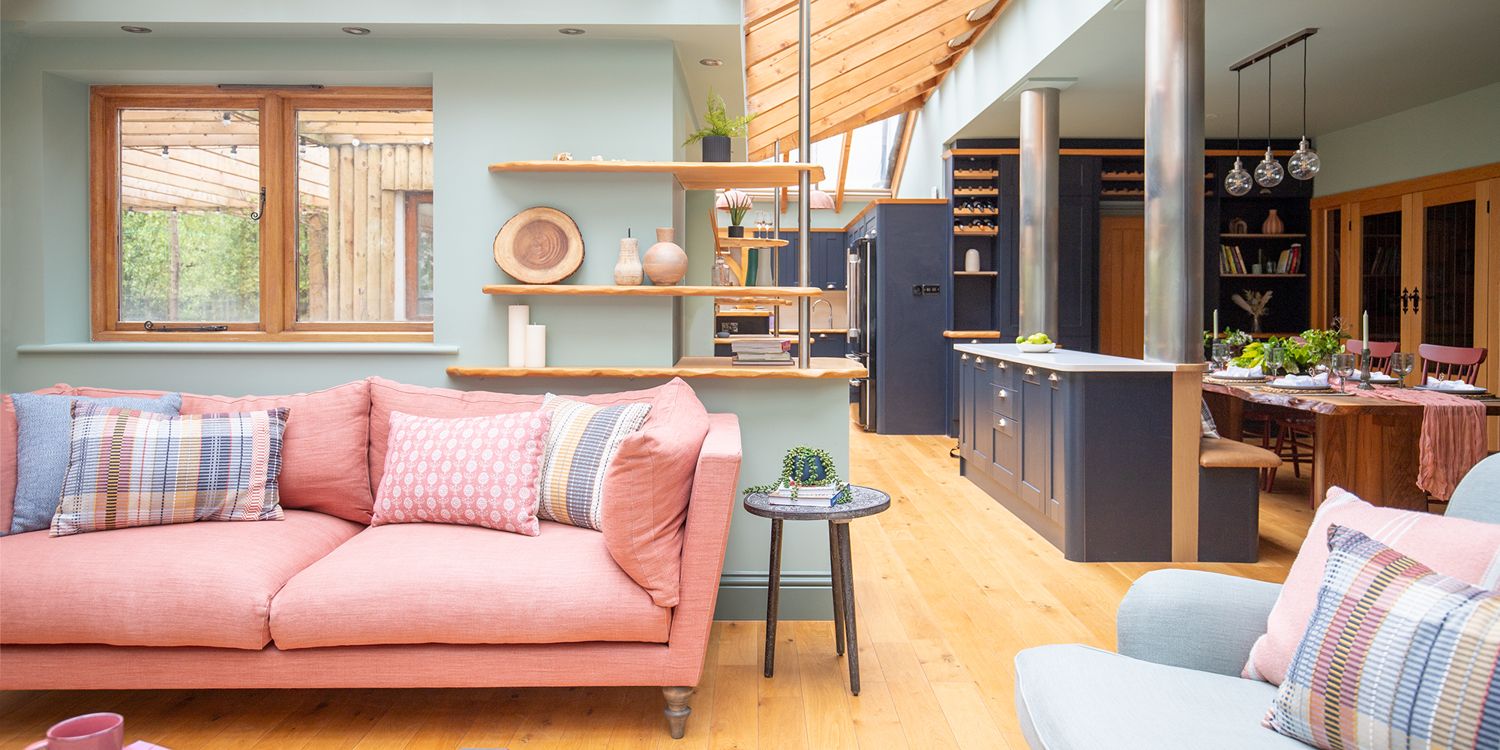 A photo of a bedroom with a large velvet bed and dressing table and stool