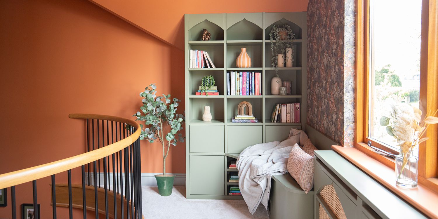 A photo of a bespoke green bookshelf in a reading corner on a mezzanine.