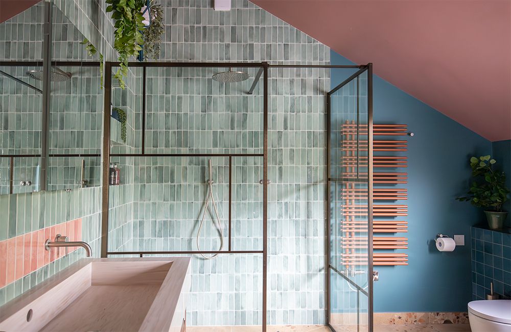 A view towards the large shower enclosure in the en suite bathroom, with sleek green tiles.