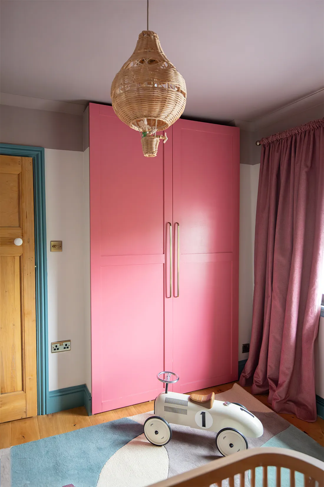 A photo showing a built in wardrobe with pink doors