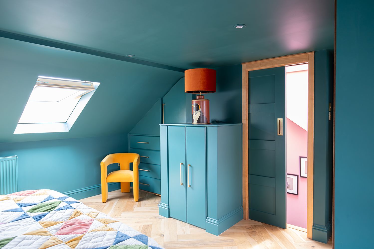 A photo showing built in storage in a bedroom all painted teal