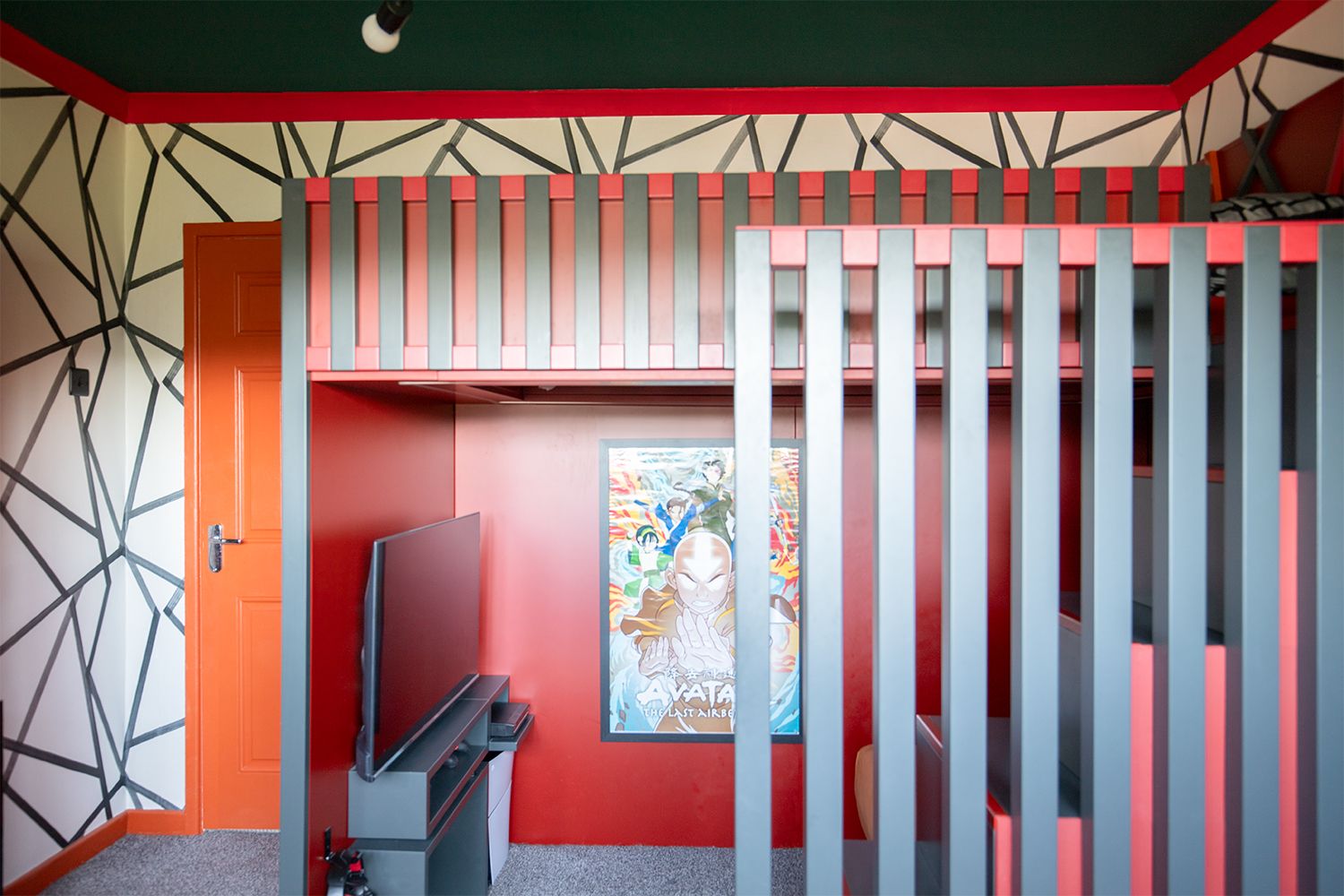 A photo of the bespoke cabin bed with dark grey and red slats.