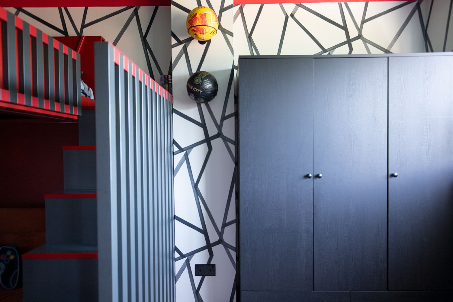A photo of the side of the cabin bed with the new black wardrobes to the right.