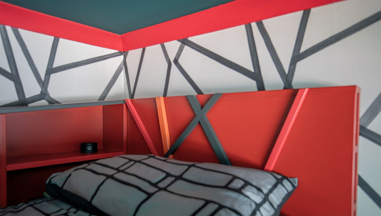 A close up photo of the cabin bed's headboard which has a 3D lines design on it to echo the wallpaper.