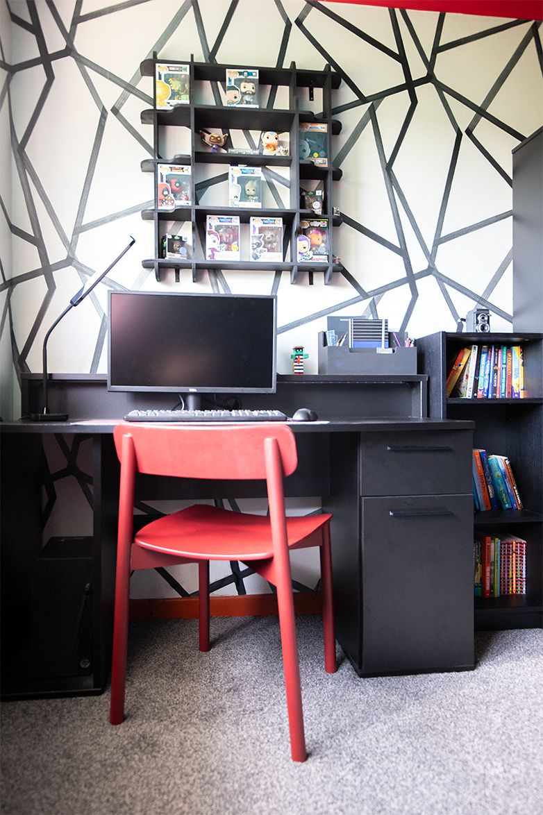 The finished room with a black desk and a red desk chair.