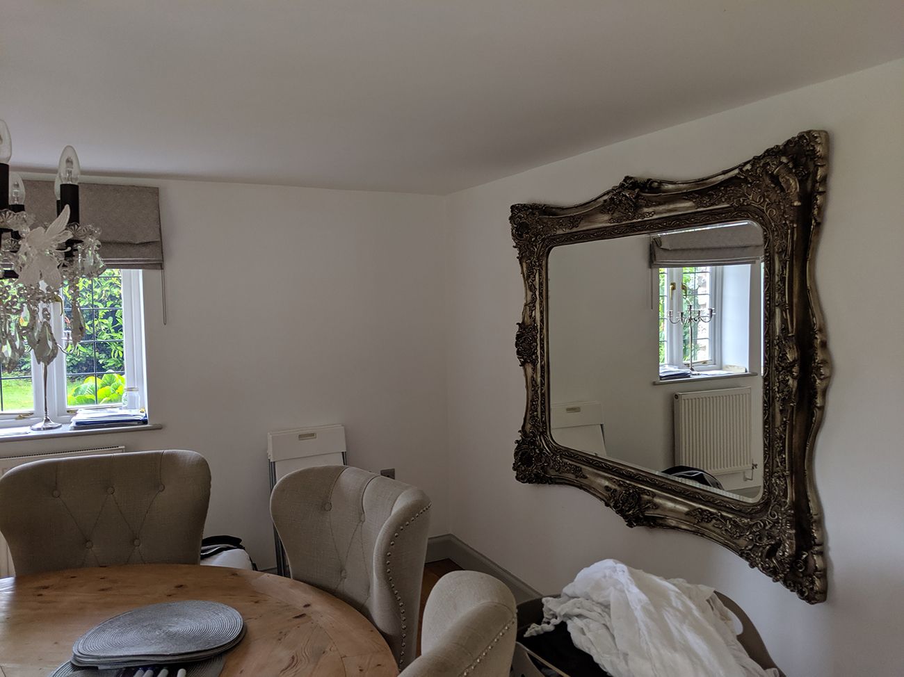 The same corner of the living room when it was the dining room.  There is a round dining table and oversized grey chairs around it.