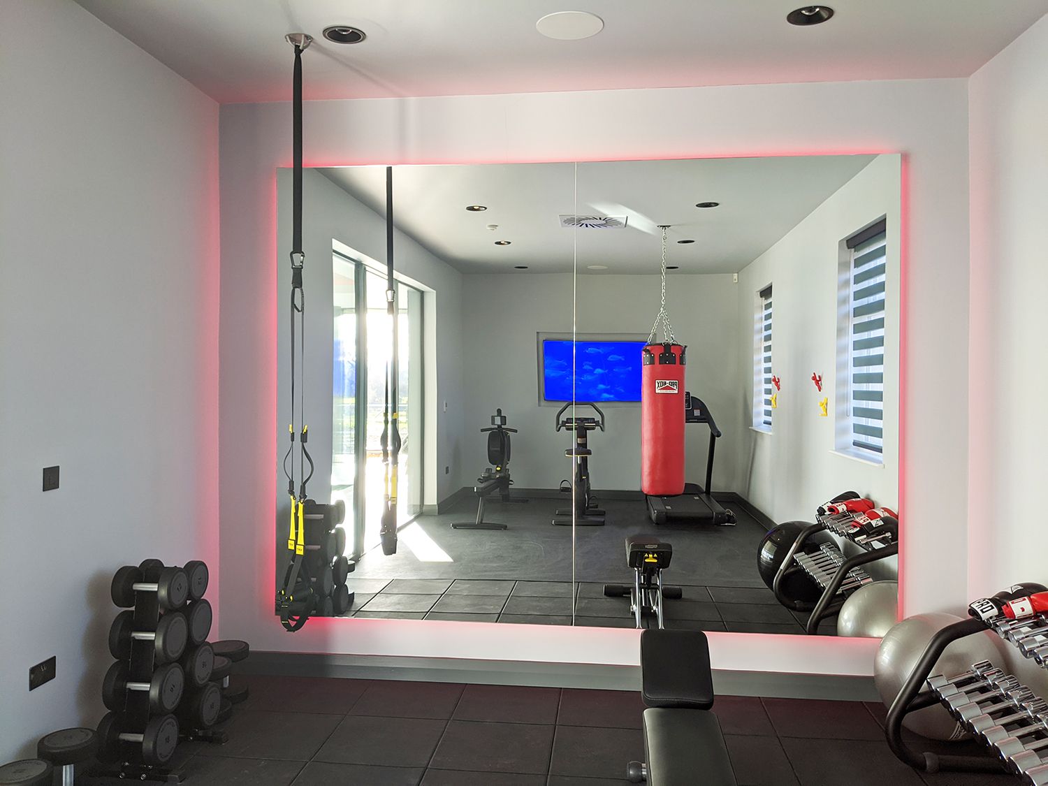 A photo of the gym area, with LED lights around a huge mirror.