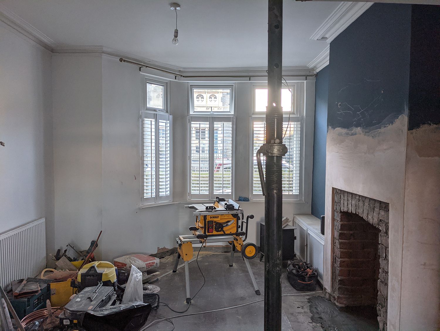 A photo showing the same side of the room before the fireplace, flooring or any decorating was done.