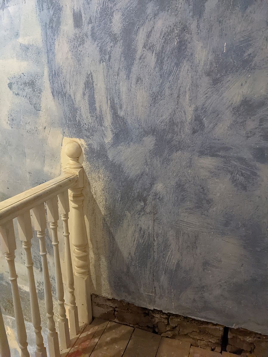 A before photo of the landing showing the white painted bannisters and un plastered walls.