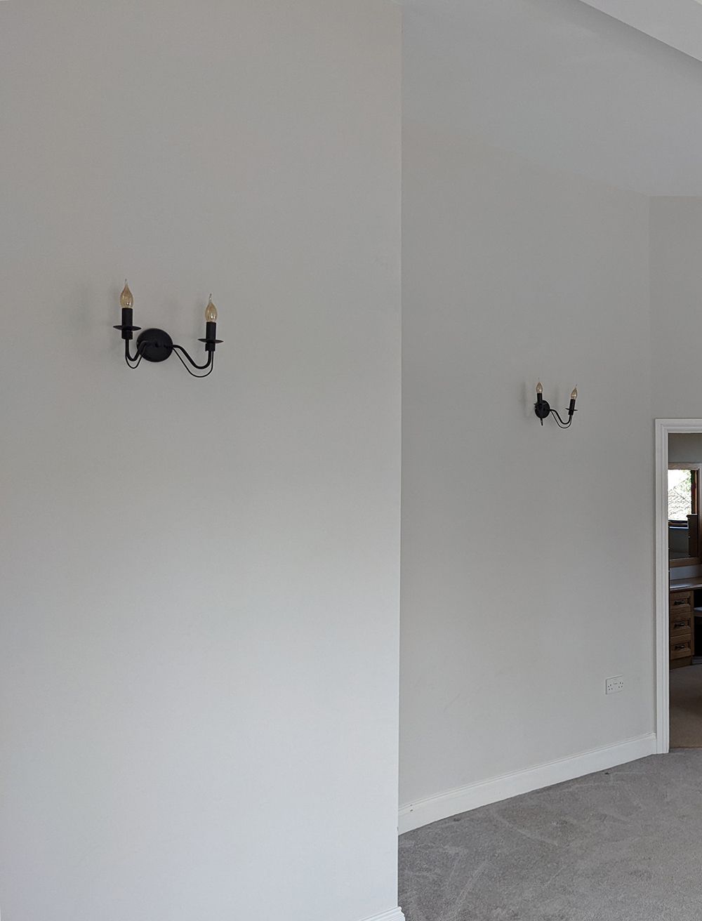 A before photo showing the old wall lights which were small and black.