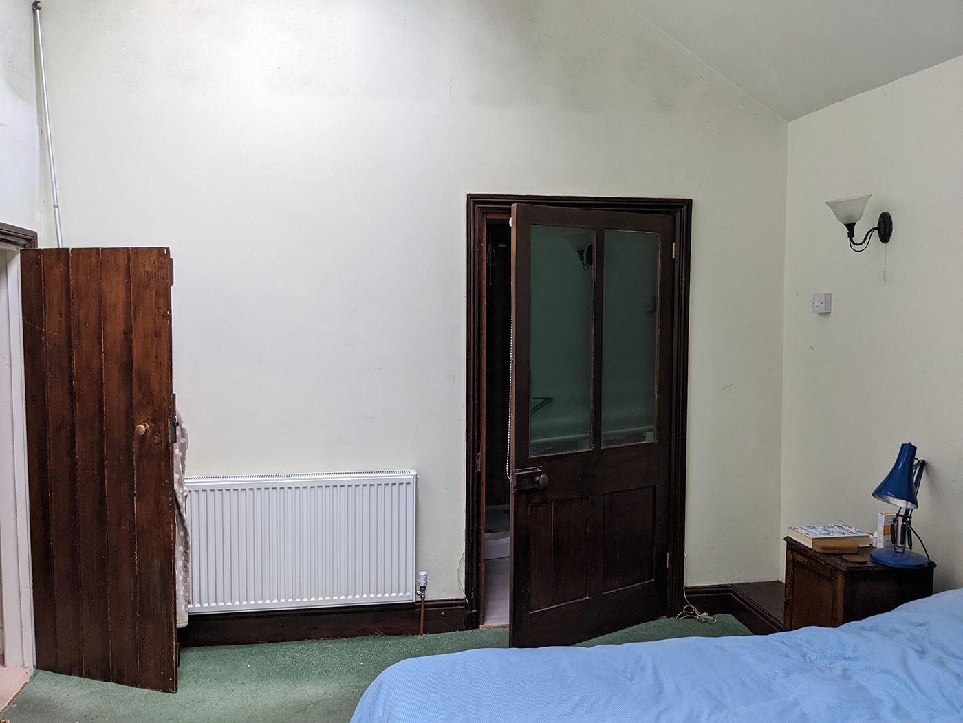 A before photo showing the en suite door and main door to the bedroom which are painted with a brown stain.