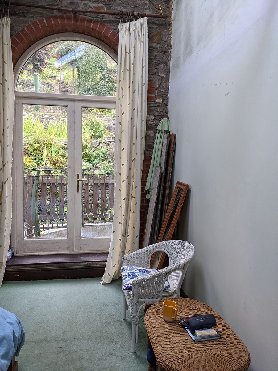 A before photo showing the French doors with undecorated walls and a faded green carpet.