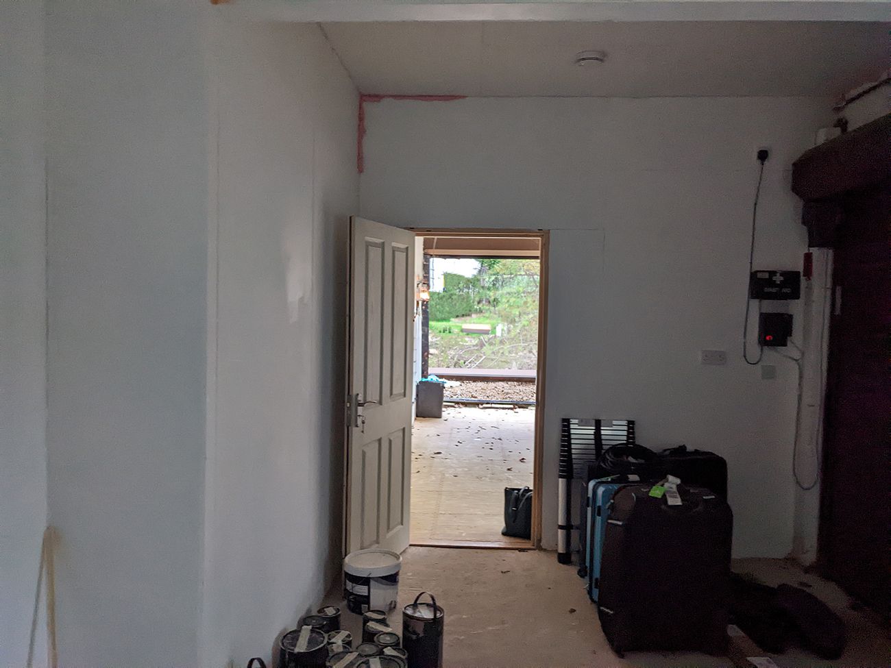 A before photo of the garage before it was converted, with unplastered walls and no lighting.