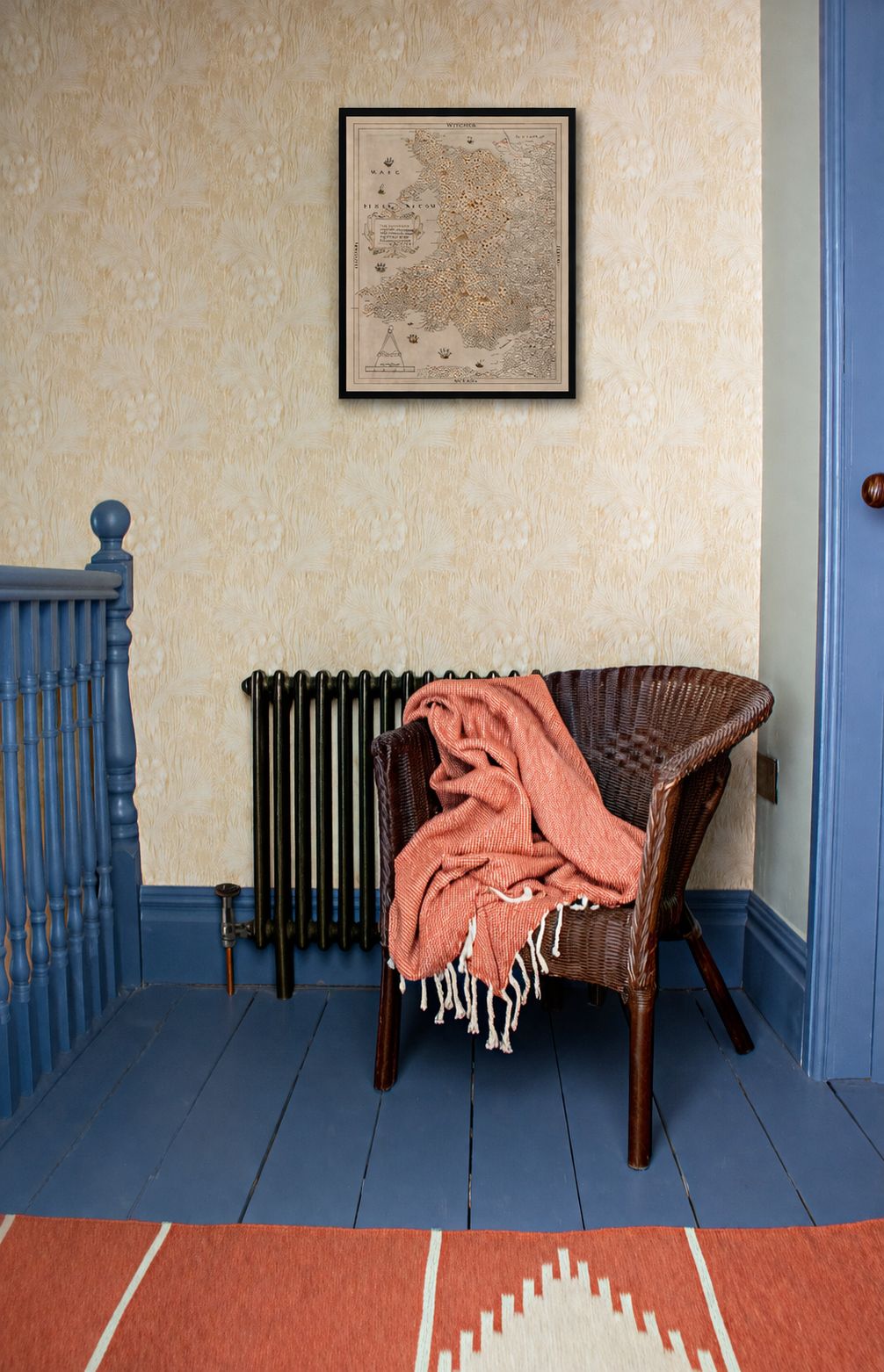 A photo of the space on the landing which has been turned into a reading nook with a chair and a rug.