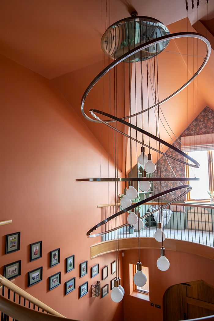 A large bespoke chandelier with five LED rings and hanging bulbs.