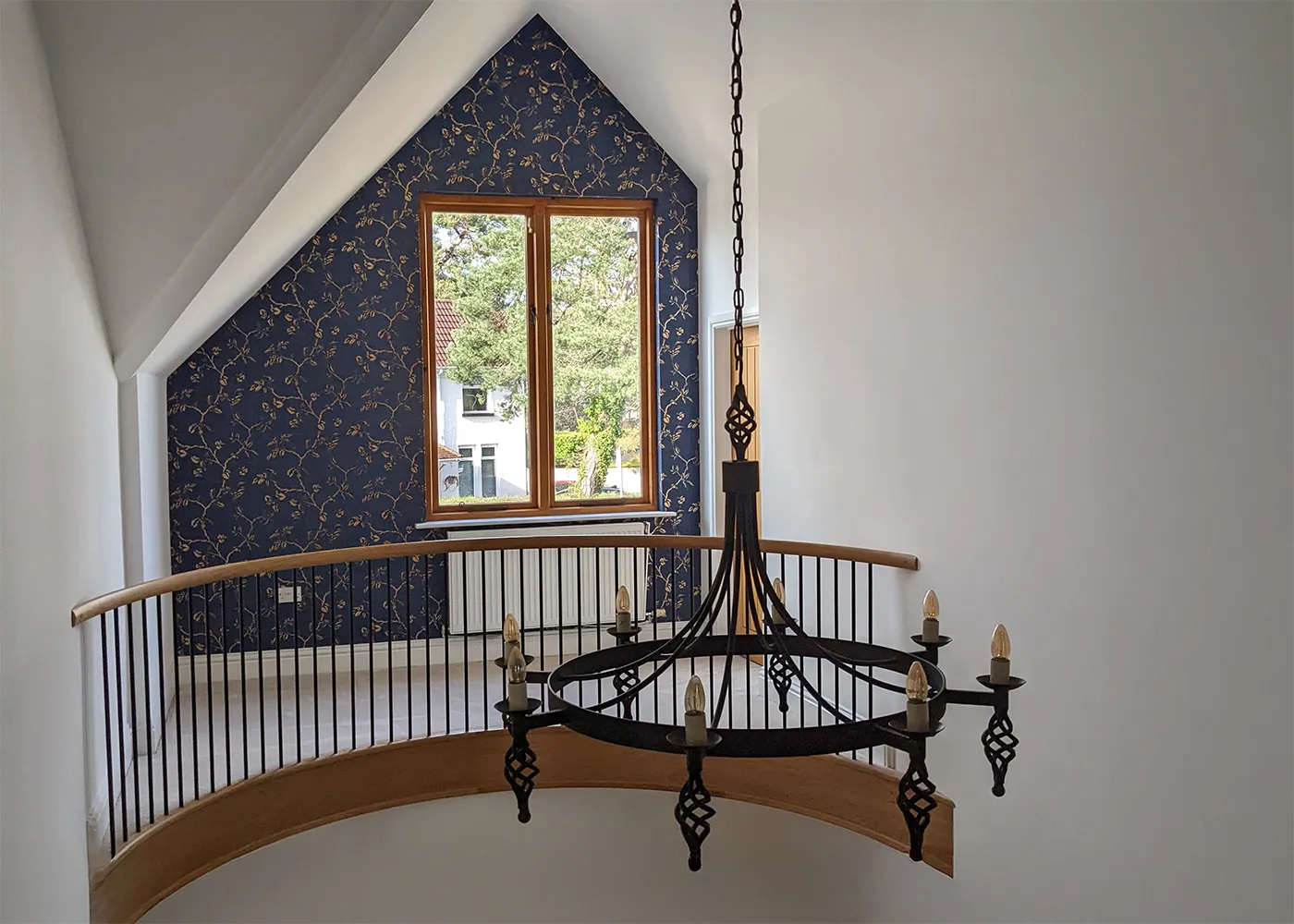 A before photo showing the white painted hallway mezzanine with a black light fitting.