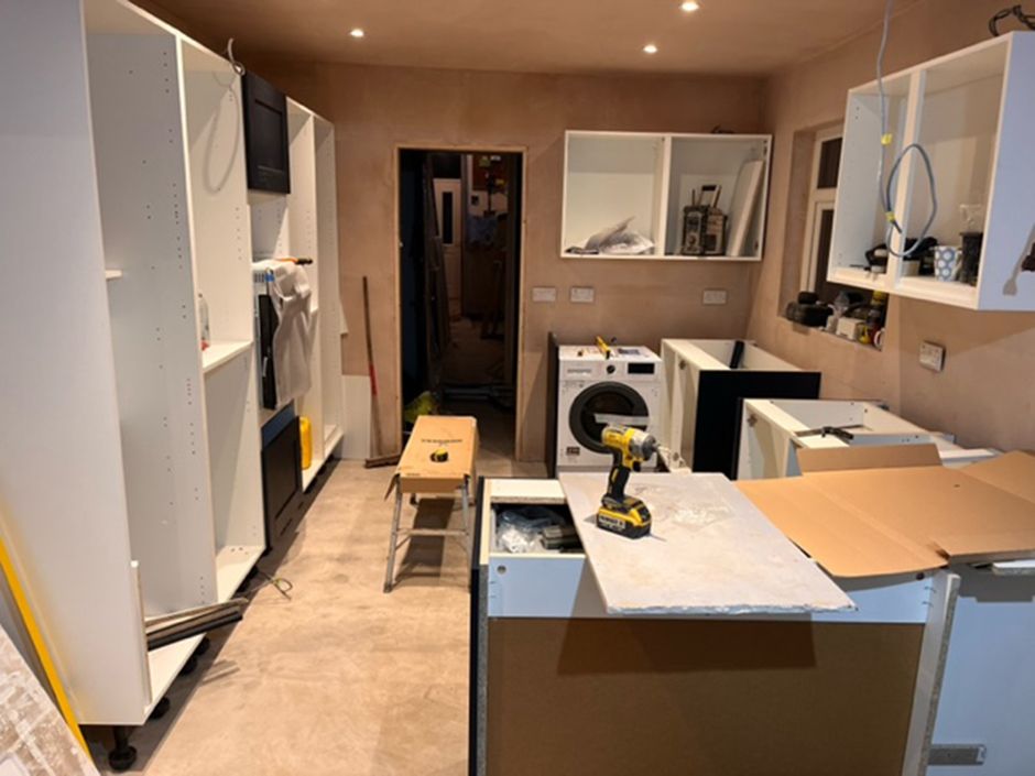 The kitchen with bare walls, no worktops and the cabinets being built.